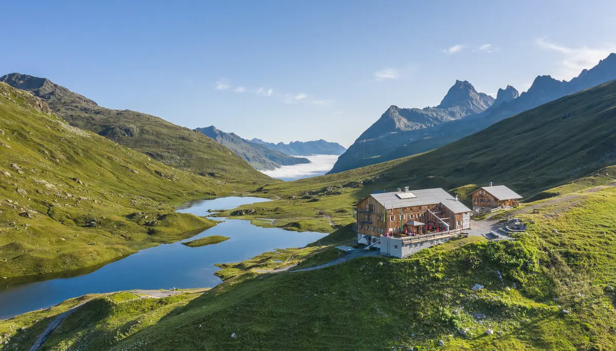 Blick auf die Neue Heilbronner Hütte vor einer Bergpanorama | © DAV Heilbronn